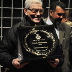 don Pietro, sorridente, ritira il Premio Bambagella